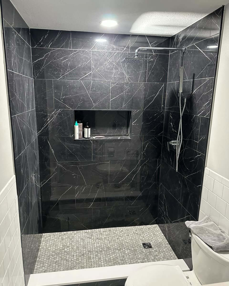 Black marble-look tiled shower by Farley Construction